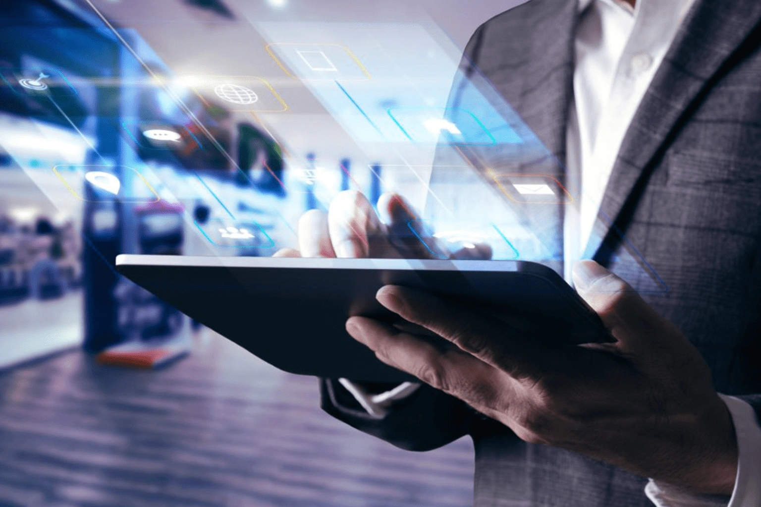 A person in a business suit holds a tablet in a modern office